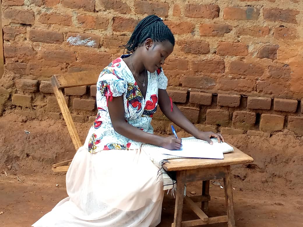 A lady filling a written interview during a study on child marriage.